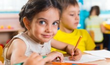 Little girl sitting at desk in school.