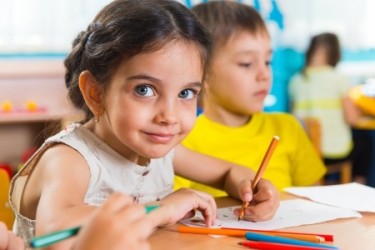 Little girl sitting at desk in school.