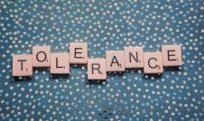 Tolerance spelled out in letter tiles on green polka dot background