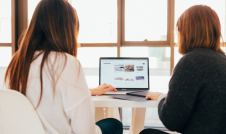 two women looking at a laptop