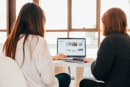 two women looking at a laptop