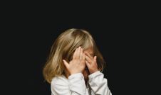 Young girl covering her eyes with her hands