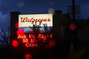 Walgreens pharmacy sign partially hidden by branch