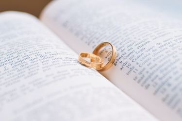 Gold wedding rings on open Bible