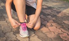 Female runner tying shoe