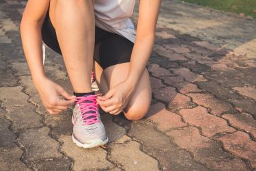 Female runner tying shoe