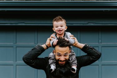 father holding son on shoulders